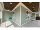 Inviting covered front porch with sage green siding, wood ceiling and a swing for relaxing at 905 E Lenoir St, Raleigh, NC 27610