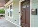 Charming front porch with a brown front door, green siding, and a functional mailbox at 905 E Lenoir St, Raleigh, NC 27610