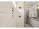Spacious tiled shower with a rainfall shower head and niche for toiletries in a modern bathroom at 905 E Lenoir St, Raleigh, NC 27610