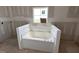 Jetted bathtub by a window ready for tile work in this new construction bathroom at 94 Royal Ave, Selma, NC 27576