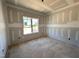 Well-lit bedroom is shown with a window and unfinished walls at 94 Royal Ave, Selma, NC 27576