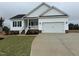 Charming, newly built one-story home with a white exterior, black shutters, and a two-car garage at 94 Royal Ave, Selma, NC 27576