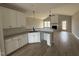 Modern kitchen featuring white cabinets, granite countertops, stainless steel appliances, and views of a gas fireplace at 94 Royal Ave, Selma, NC 27576