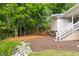 Landscaped backyard features a retaining wall, steps up to the house, mature trees, and new mulch at 1010 Cobb St, Durham, NC 27707