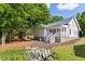 Backyard view showcasing the home's exterior, covered porch, and landscaped yard with mature trees at 1010 Cobb St, Durham, NC 27707