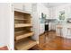 A kitchen with white cabinets, stainless steel appliances, wood floors, and slide out storage at 1010 Cobb St, Durham, NC 27707