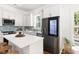 A kitchen with white cabinets, stainless steel appliances, a kitchen island with barstools and wood floors at 1010 Cobb St, Durham, NC 27707