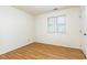 Bright bedroom featuring a window with blinds, light-colored walls, and wood-look flooring at 1015 Boathouse Ct, Raleigh, NC 27615