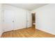 Bedroom with hardwood floors, a closed door, and an open door leading to an upstairs hallway at 1015 Boathouse Ct, Raleigh, NC 27615