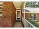 Charming front porch featuring a brick facade, a white railing, and a welcoming front door at 1015 Boathouse Ct, Raleigh, NC 27615