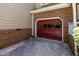 View of the red garage door, flanked by brick and siding, adding character to the home's exterior at 1015 Boathouse Ct, Raleigh, NC 27615