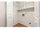 Compact laundry room with built-in shelving, washer/dryer hookups, and light-colored walls at 1015 Boathouse Ct, Raleigh, NC 27615
