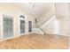 Spacious living room with hardwood floors, a staircase, and large windows that offer plenty of natural light at 1015 Boathouse Ct, Raleigh, NC 27615