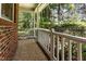 Covered porch showcasing brick siding, stone flooring, and a view of the wooded area at 1015 Boathouse Ct, Raleigh, NC 27615