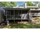Back of house view, including a screened in porch, lawn and shade trees at 1015 Boathouse Ct, Raleigh, NC 27615