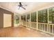 Cozy screened porch with wood flooring, a ceiling fan, and a view of the wooded surroundings at 1015 Boathouse Ct, Raleigh, NC 27615