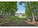 View of a spacious backyard with mature trees, a wooden fence, and a swingset at 10504 Carsons Creek Dr, Zebulon, NC 27597
