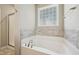 Bathroom with white soaking tub with a view to the garden and separate shower stall at 10504 Carsons Creek Dr, Zebulon, NC 27597