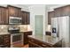 Modern kitchen featuring stainless steel appliances, granite countertops, and dark wood cabinetry at 10504 Carsons Creek Dr, Zebulon, NC 27597