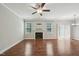 Spacious living room featuring a fireplace, ceiling fan, hardwood floors and light gray walls at 10504 Carsons Creek Dr, Zebulon, NC 27597