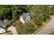 Overhead aerial shows the white house is surrounded by mature trees and established landscaping at 106 Windstream Way, Cary, NC 27518