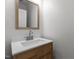 Bathroom vanity featuring a wood cabinet, modern faucet, and a framed mirror at 106 Windstream Way, Cary, NC 27518