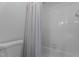 Bathroom featuring white tiled walls, a toilet and a shower-bathtub with a patterned curtain at 106 Windstream Way, Cary, NC 27518