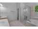 Well-lit bathroom features a tub, shower, tile floors, and double sinks at 106 Windstream Way, Cary, NC 27518
