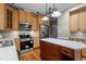 Well-appointed kitchen featuring stainless steel appliances, light wood cabinetry, and a center island at 106 Windstream Way, Cary, NC 27518