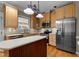 Modern kitchen featuring stainless steel appliances, light wood cabinetry, and a center island for prep space at 106 Windstream Way, Cary, NC 27518