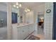 Bright bathroom with double sinks, white cabinets, decorative wallpaper and an open doorway to the bedroom at 10608 Thornbury Crest Ct Ct, Raleigh, NC 27614