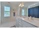 Bright bathroom with double sinks, white cabinets, a large mirror, and decorative wallpaper and a window at 10608 Thornbury Crest Ct Ct, Raleigh, NC 27614