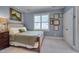 Bedroom with blue walls, a bed, a window with shutters, decorative artwork and a dark wooden nightstand at 10608 Thornbury Crest Ct Ct, Raleigh, NC 27614
