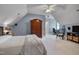 Upstairs bedroom with sloped ceilings, a dark bed frame, an armoire, and a separate workspace at 10608 Thornbury Crest Ct Ct, Raleigh, NC 27614