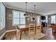 Dining room with wood table, pendant lighting, and views into the living room with fireplace at 10608 Thornbury Crest Ct Ct, Raleigh, NC 27614