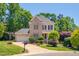 Charming two-story brick home with manicured lawn and lush landscaping under a clear blue sky at 10608 Thornbury Crest Ct Ct, Raleigh, NC 27614