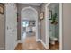 Hallway with arched entry to kitchen and view to a half bathroom; hardwood floors at 10608 Thornbury Crest Ct Ct, Raleigh, NC 27614