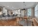 Open kitchen and dining area with white cabinets, barstool seating, and hardwood flooring at 10608 Thornbury Crest Ct Ct, Raleigh, NC 27614