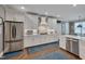 Bright kitchen features white cabinets, stainless steel appliances, and hardwood floors at 10608 Thornbury Crest Ct Ct, Raleigh, NC 27614