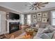 Cozy living room featuring a fireplace, modern ceiling fan and comfortable seating at 10608 Thornbury Crest Ct Ct, Raleigh, NC 27614