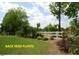 Backyard features meticulously landscaped garden beds and classic white fencing bordering the property at 107 Norwood Dr, Clayton, NC 27527
