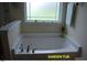 Garden tub beneath a window, perfect for relaxation in the main bathroom at 107 Norwood Dr, Clayton, NC 27527