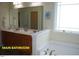 Main bathroom features double sinks, a large mirror, and a bathtub with a window at 107 Norwood Dr, Clayton, NC 27527