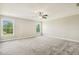 Spacious primary bedroom with neutral carpet, ceiling fan, and large windows providing natural light at 107 Southern Acres Dr, Fuquay Varina, NC 27526