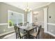 Bright dining room area with a chandelier, table, seating, and view of the home's exterior at 107 Southern Acres Dr, Fuquay Varina, NC 27526