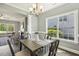 Dining room features a modern chandelier, table with seating for four, and view into an adjacent living room at 107 Southern Acres Dr, Fuquay Varina, NC 27526