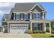 Charming two-story home featuring a two-car garage, gray siding, and a well-manicured lawn with fresh landscaping at 107 Southern Acres Dr, Fuquay Varina, NC 27526
