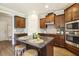 Beautiful kitchen featuring wood cabinets, granite countertops, stainless steel appliances, and a large island with bar stool seating at 107 Southern Acres Dr, Fuquay Varina, NC 27526