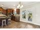 Well-lit kitchen boasts stainless steel appliances, wood cabinets, granite counters, and an island with stool seating at 107 Southern Acres Dr, Fuquay Varina, NC 27526