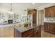 Open concept kitchen boasts stainless steel appliances, granite countertops and island with seating, adjacent to living and staircase at 107 Southern Acres Dr, Fuquay Varina, NC 27526